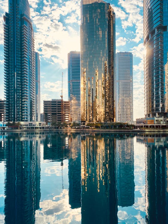 Modern city district with skyscrapers reflecting in pond