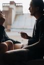 一对夫妇坐在窗台旁，在室内一起吸烟，共享片刻时光