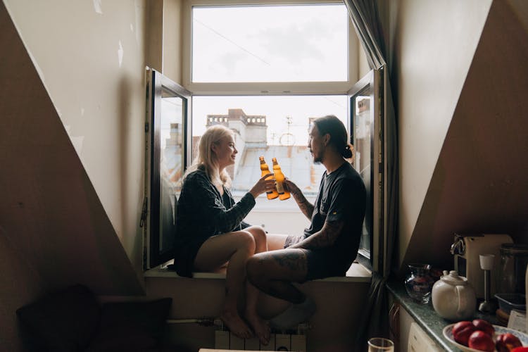 A Couple Having A Beer By The Window