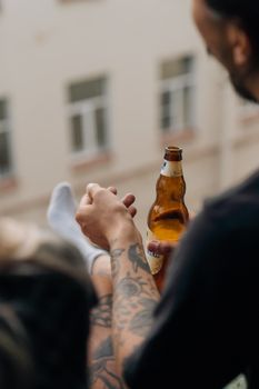 外面有人拿着啤酒瓶，纹着身，专注于放松和休闲