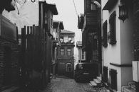 Grayscale Photo of Car Parked Beside Building