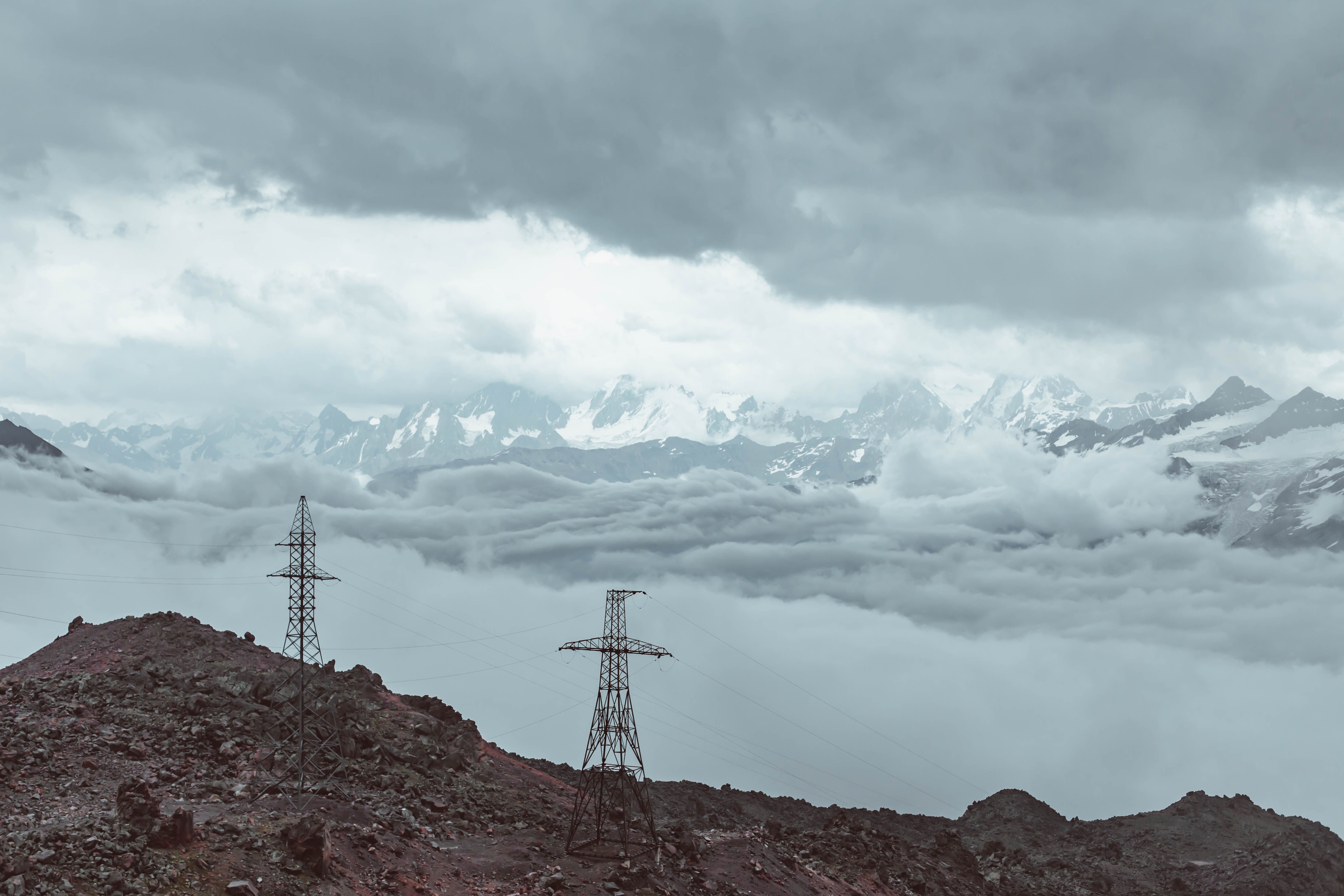 High voltage power lines against mountains in sunset · Free Stock Photo