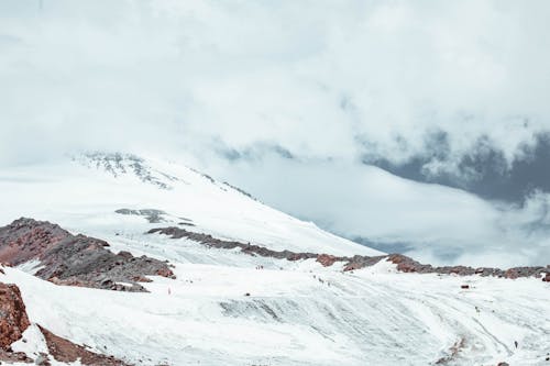 Picturesque view of snowy mountain peak with icy slope on height in daylight