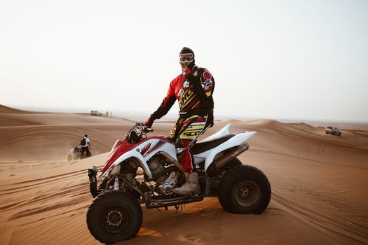 Man in helmet on quad bike in desert