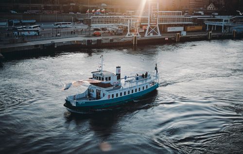 Free From above of contemporary sailing ship on calm rippled water near city port at sunset Stock Photo