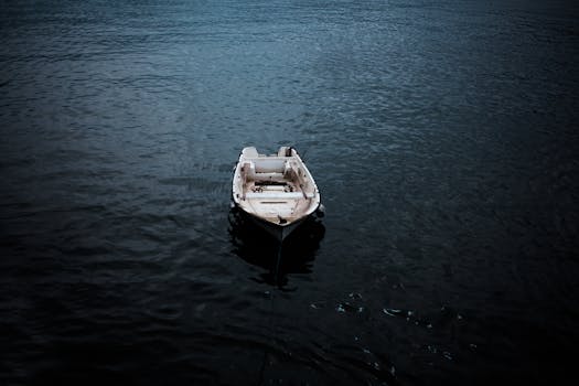 一艘孤独的船静静地漂浮在平静的水面上，营造出一种宁静而隔绝的氛围