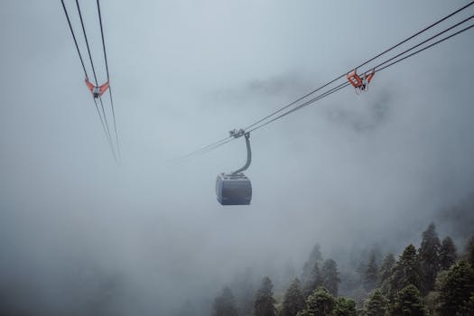 Cable car traversing through misty mountain landscapes, capturing a serene journey.