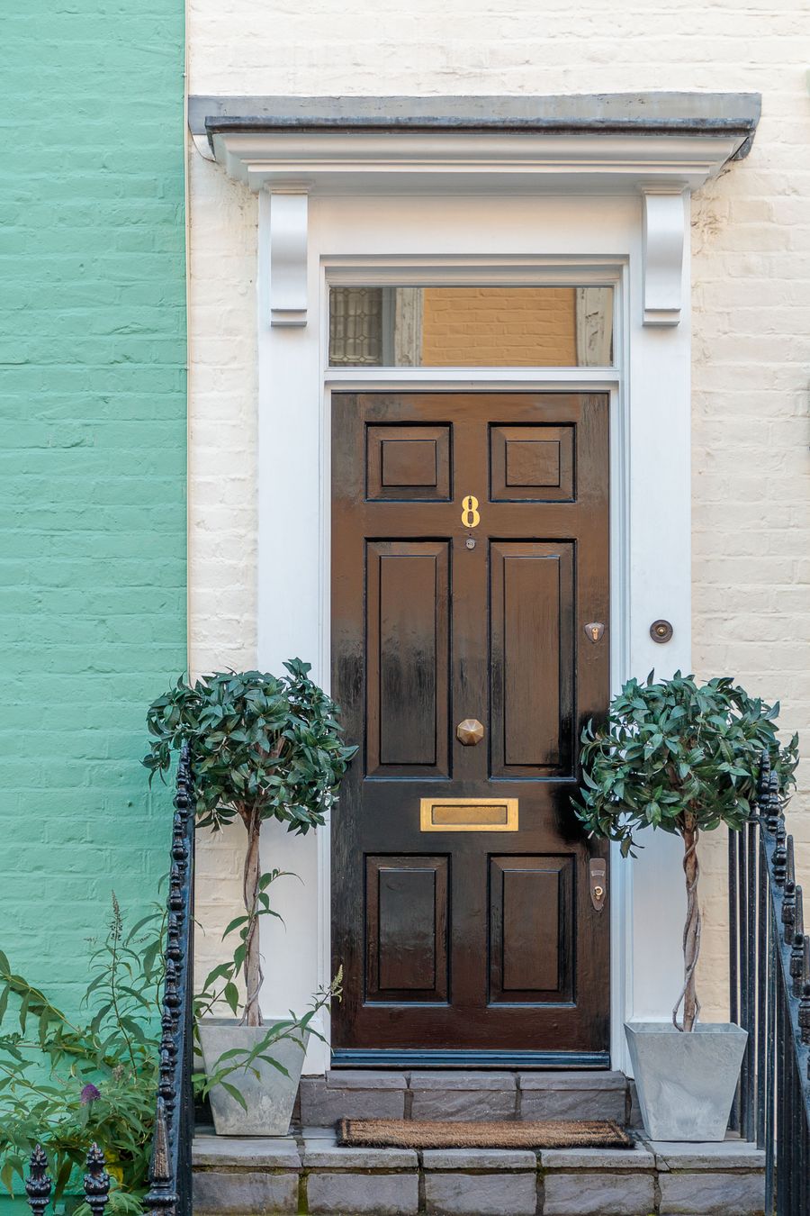 Smart British front entrance with stone step and iron railings
