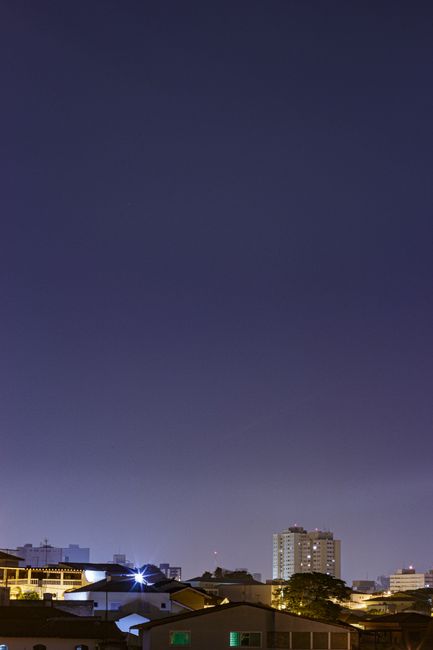 From below of contemporary residential building exteriors under purple sky at sundown in city