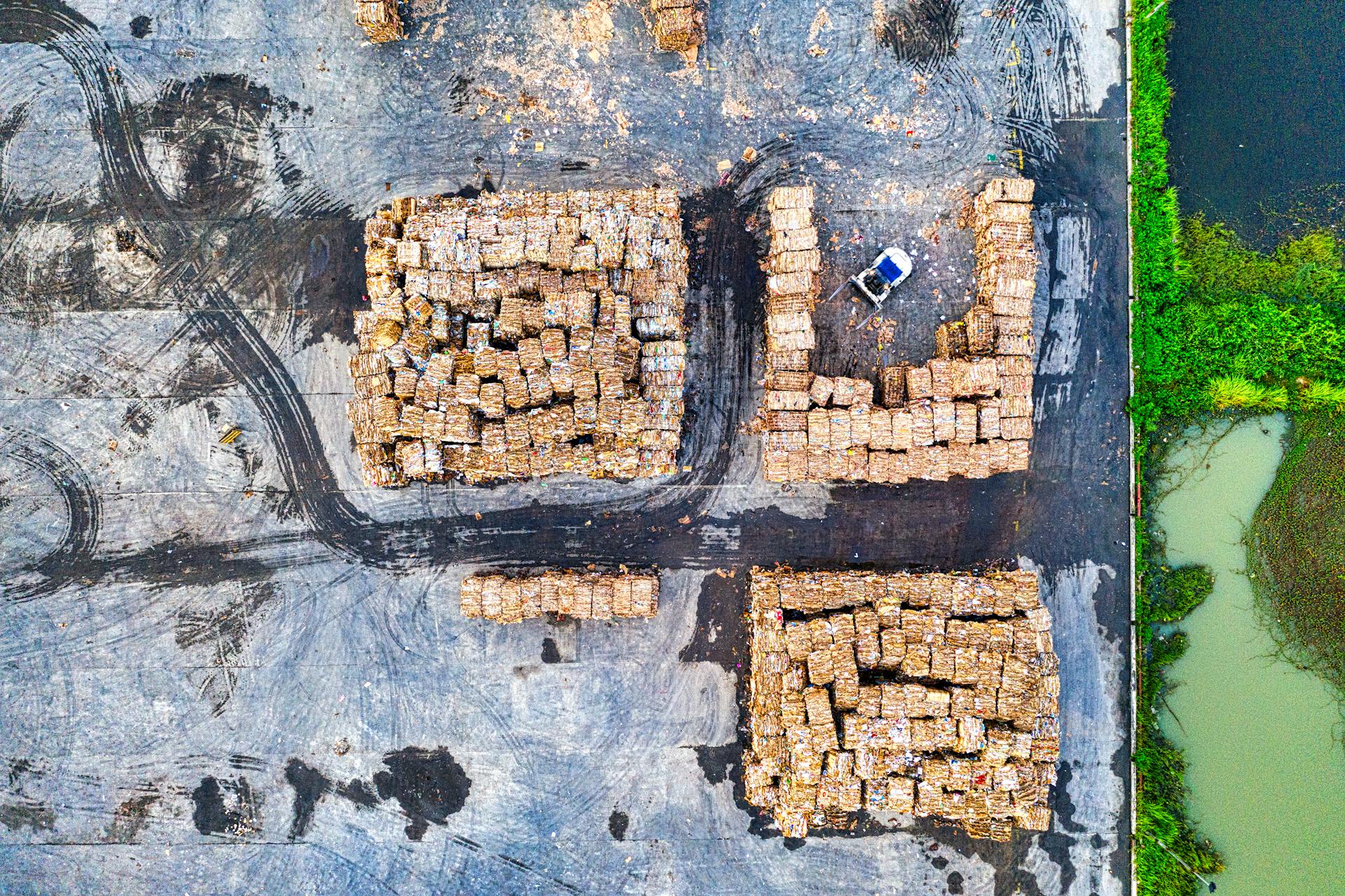 Aerial view capturing stacked wooden pallets in an industrial area, highlighting logistical and environmental themes.