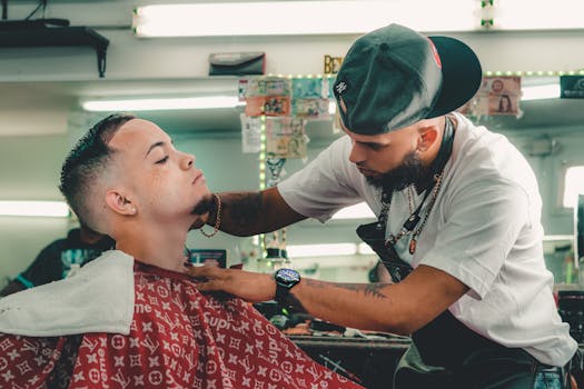 A barber skillfully trims a young man's beard in a contemporary barber shop.
