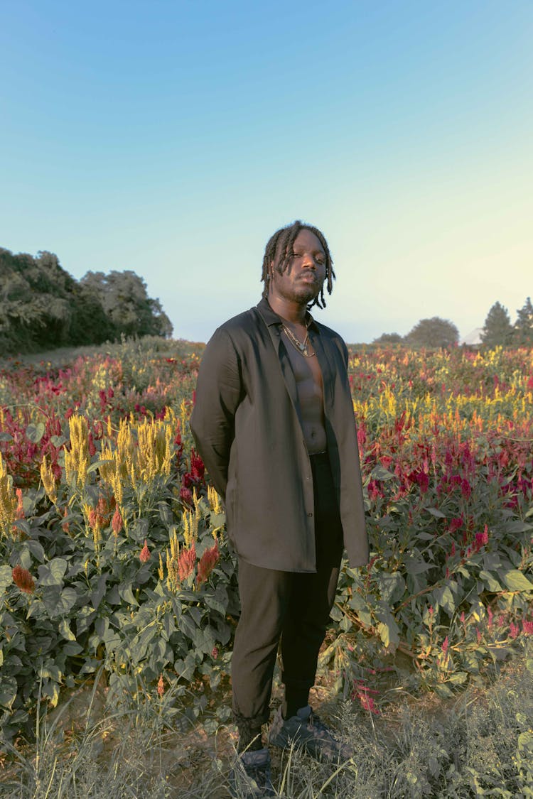 Cheerful Black Man Standing In Field