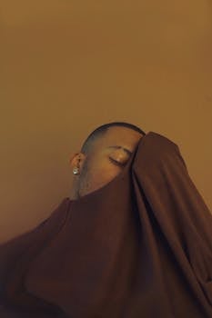 Stylish portrait of a serene man enveloped in warm, organic tones.