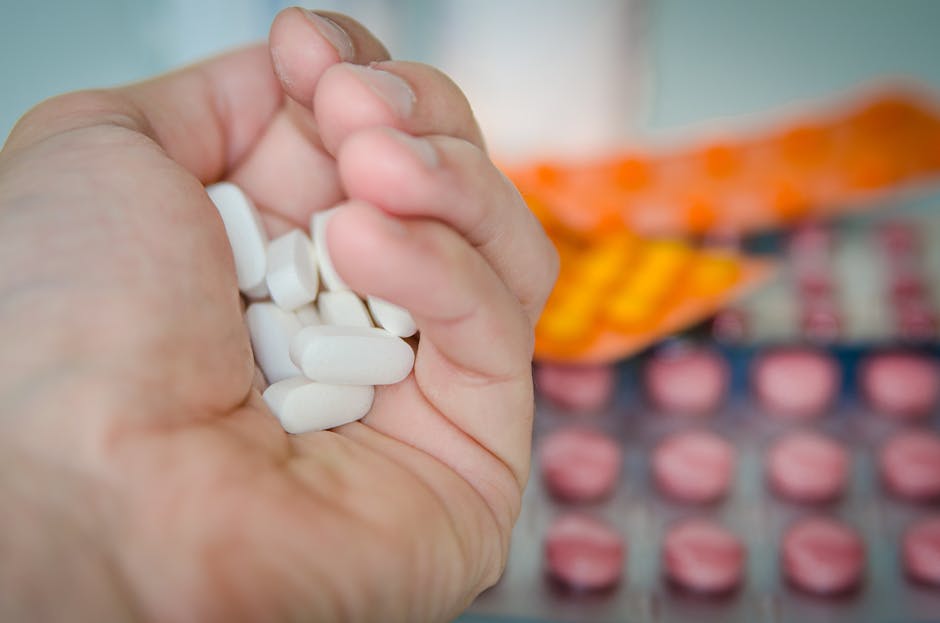 White Oval Medication Tablets in Hand