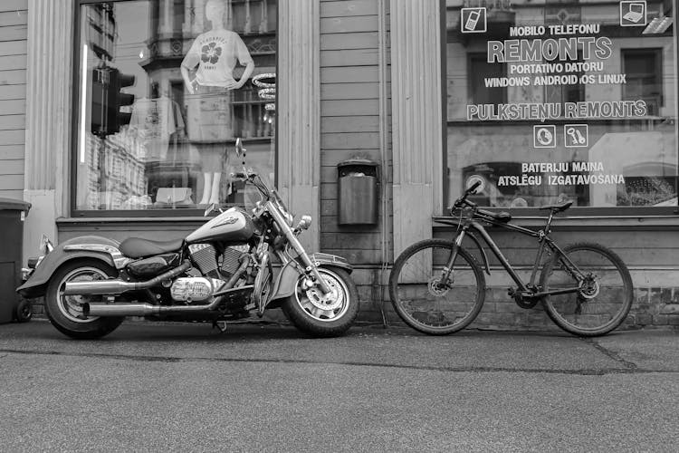 Retro Bike Parked With Motorcycle Near Shop Window