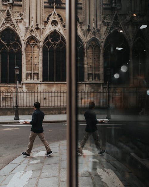 Gratis Un Hombre Que Camina Por Notre Dame De Paris Mientras Lleva Un Paquete Foto de stock