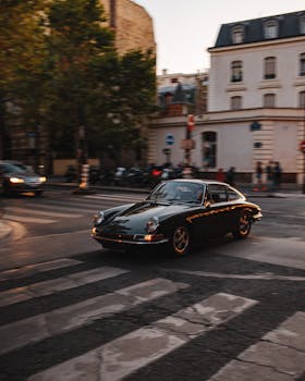 Vintage car driving through a European street, evoking a sense of nostalgia and classic elegance.