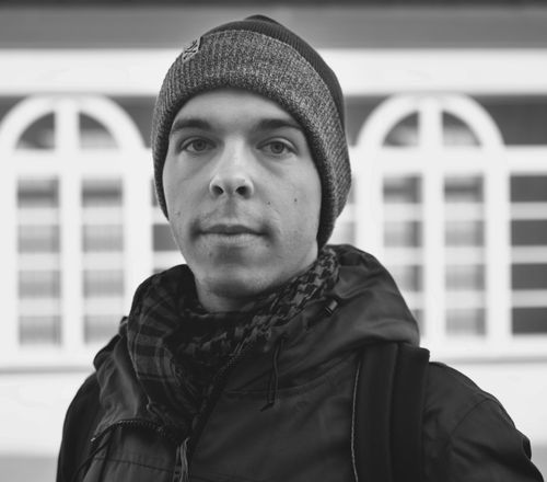 Free Monochrome close-up portrait of a man in a beanie and scarf looking directly at the camera Stock Photo