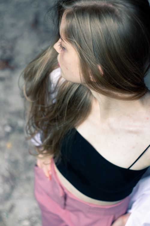 Free Young woman posing in a black crop top with long hair outdoors. Stock Photo
