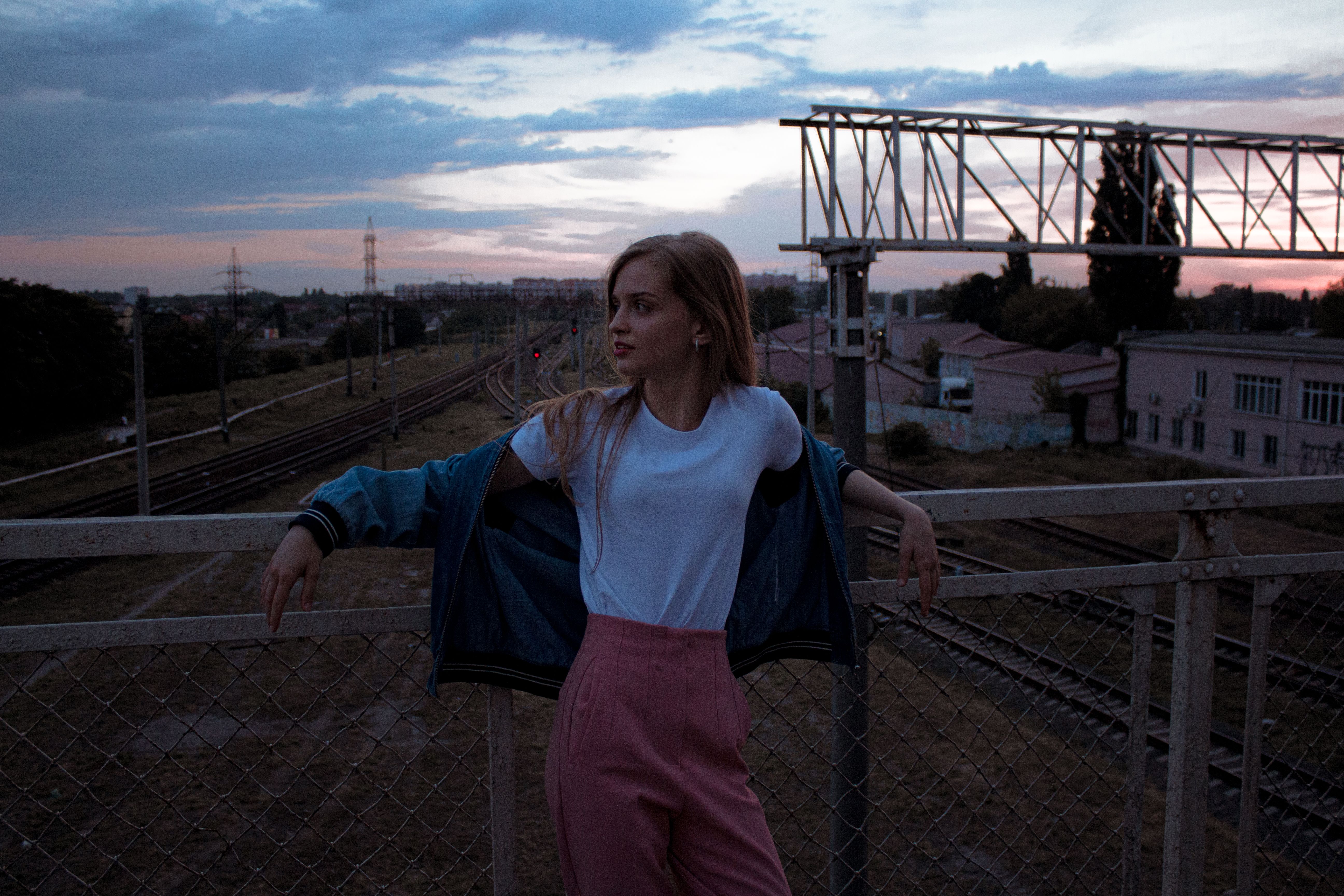 A Young Woman Leaning on Metal Railing · Free Stock Photo