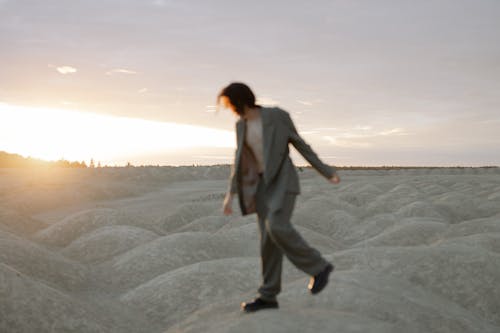 Woman in Brown Coat Standing on Brown Sand · Free Stock Photo