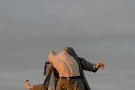 一位男性舞者在多云的天空下出色地展示了艺术的灵活性