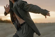 日落时分，一位男舞者身着西装在沙漠中展示当代舞蹈