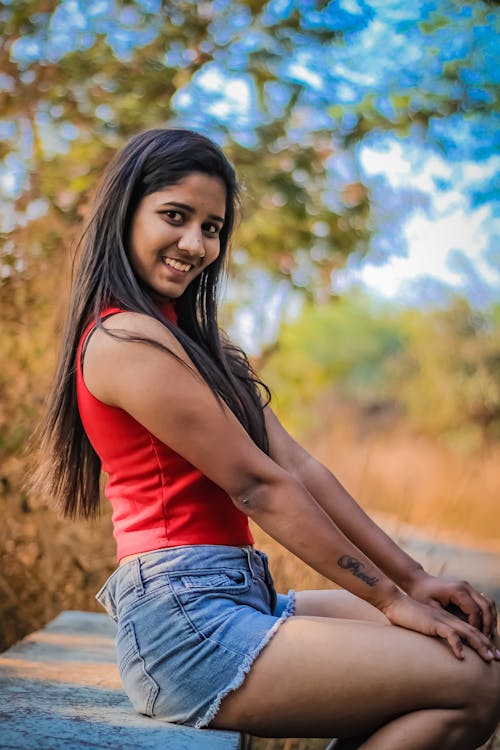 A Beautiful Smiling Woman in Red Tank Top and Denim Shorts