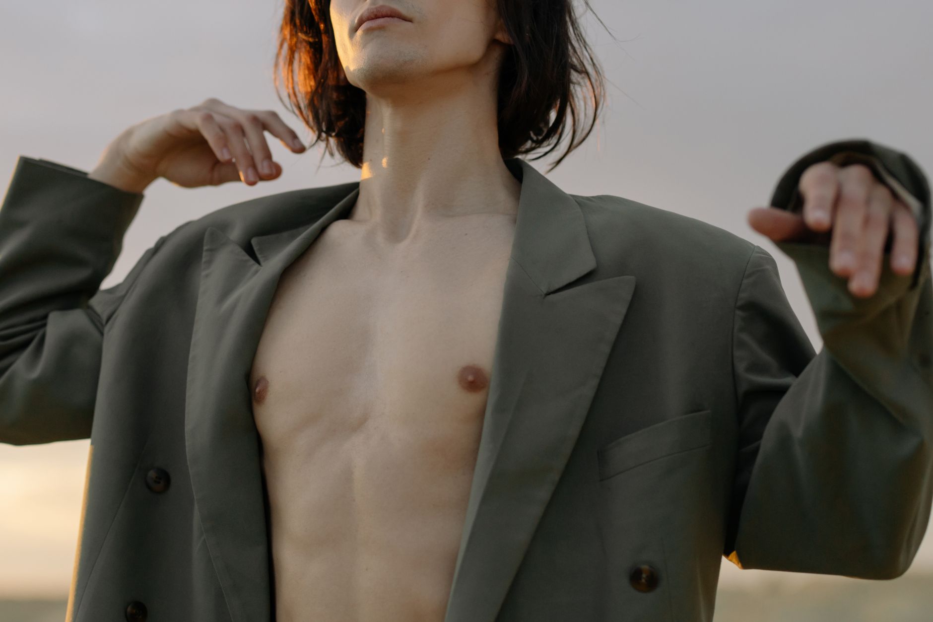 Stylish fashion shot of a shirtless model wearing an oversized suit, embodying modern elegance and confident expression.