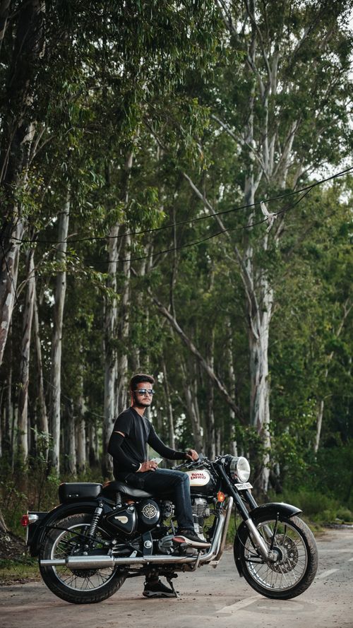 Free A man riding a motorcycle through a scenic forest, showcasing adventure and lifestyle. Stock Photo