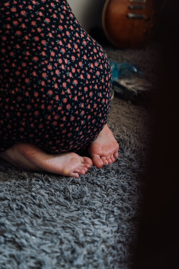 A Person In A Floral Dress Kneeling On The Floor