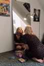 A Young Woman Putting on Makeup While Kneeling on the Floor
