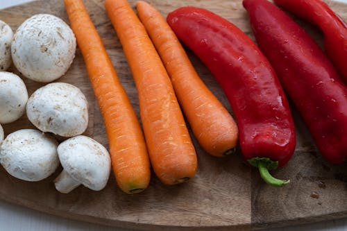 Free Close-Up Shot of Vegetables on a Wooden Chopping Board Stock Photo
