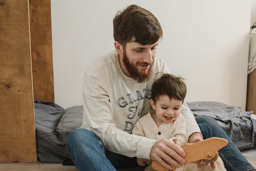 Father and Son Playing with Wooden Toy