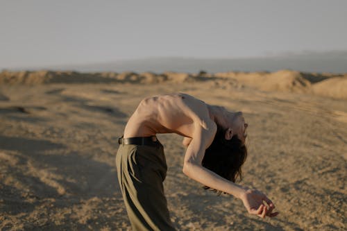 Free Woman in Brown Dress Standing on Brown Sand Stock Photo