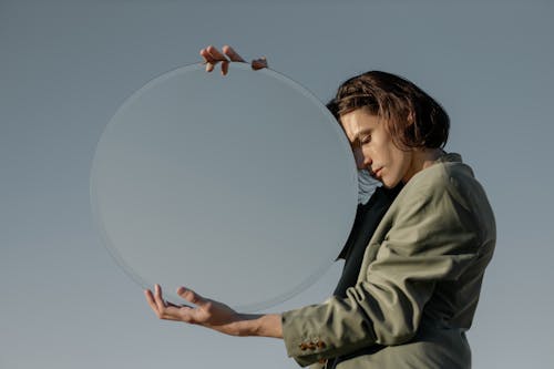 Girl in Green Jacket Holding Clear Glass Ball