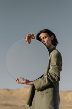 一幅用圆镜在沙漠环境中描绘的创意人像