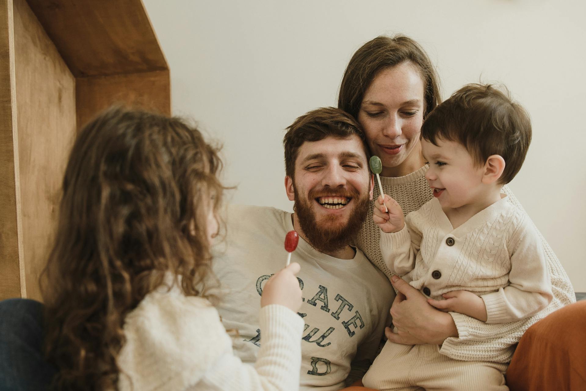 Happy Family with Children Holding Lollipops