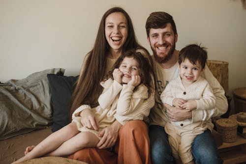 Happy Family Sitting on Brown Couch