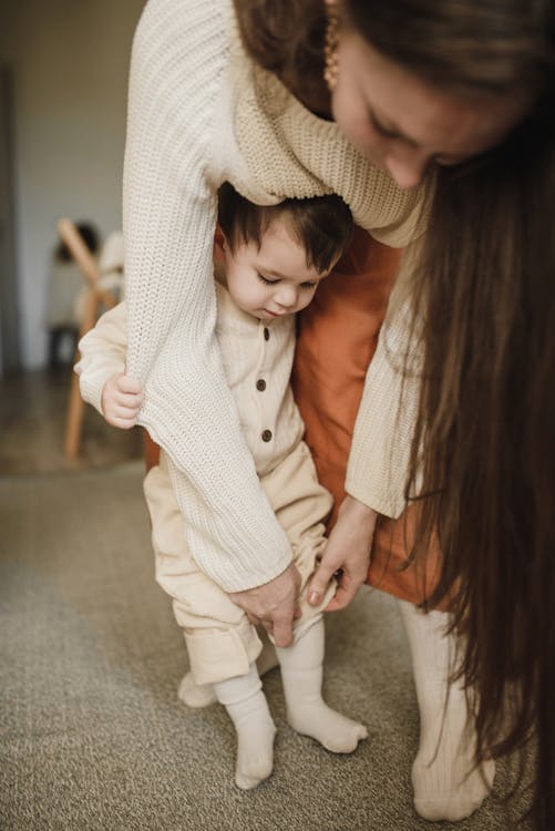 A Woman Helping her Young Son with his Clothes