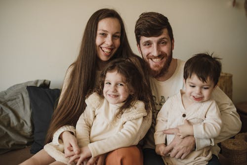 Man and Woman Sitting on Couch with Children