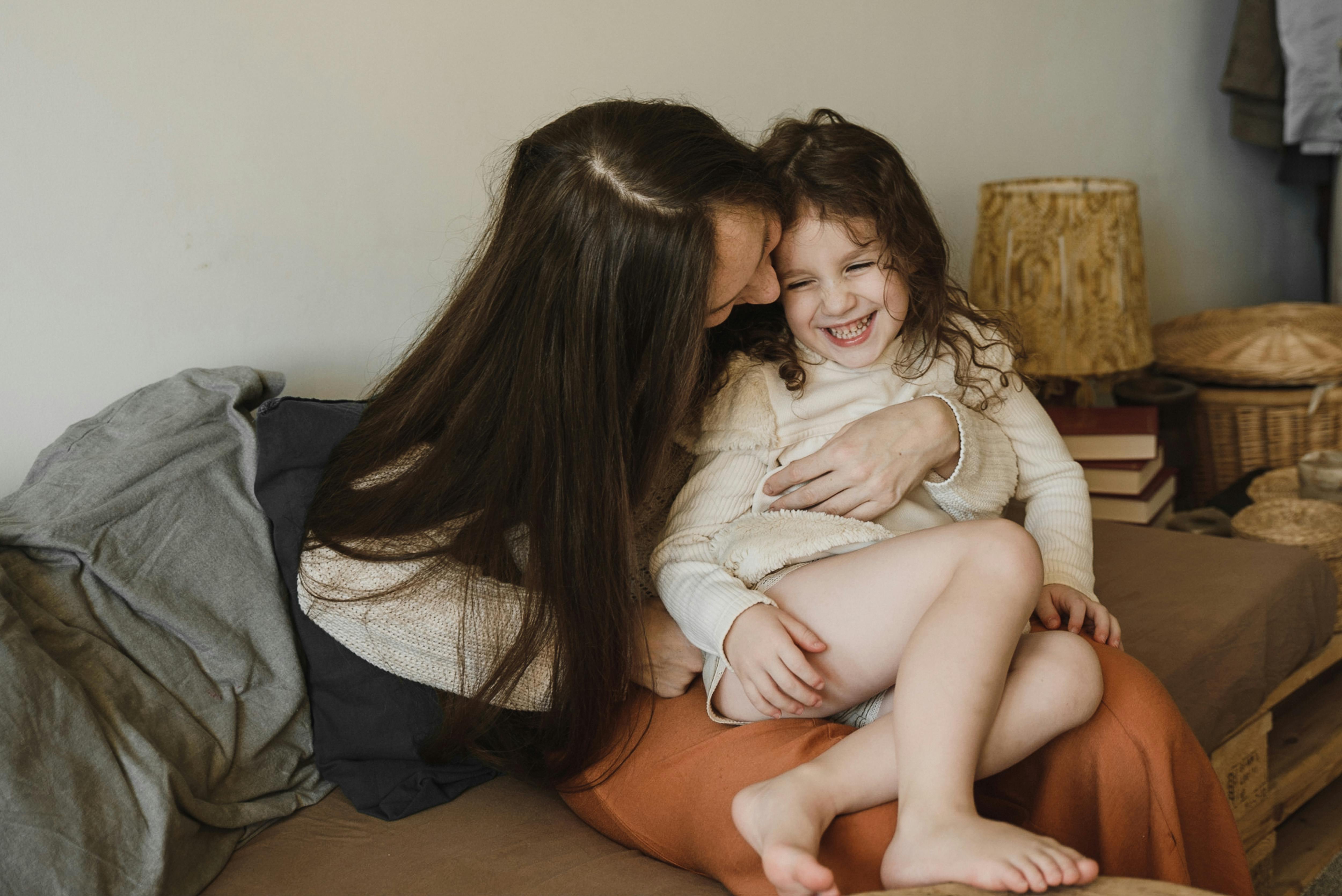 mother tickling her cute daughter