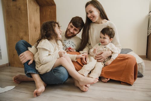Free A Happy Family Sitting Together on the Floor Stock Photo