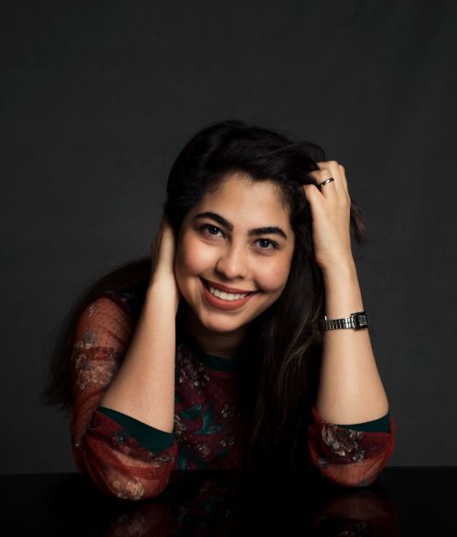 Free Charming portrait of a woman smiling against a dark backdrop, showcasing joyful expression. Stock Photo