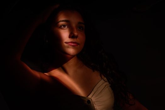 Artistic portrait featuring a woman with dramatic chiaroscuro lighting, capturing a contemplative mood.. pexels, artistic, po