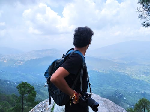 Free A Man with a Camera at a Tourist Spot with a Scenic View Stock Photo