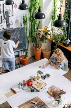 Adult students engage in an artistic workshop, focusing on blackboard illustration and sketching indoors.