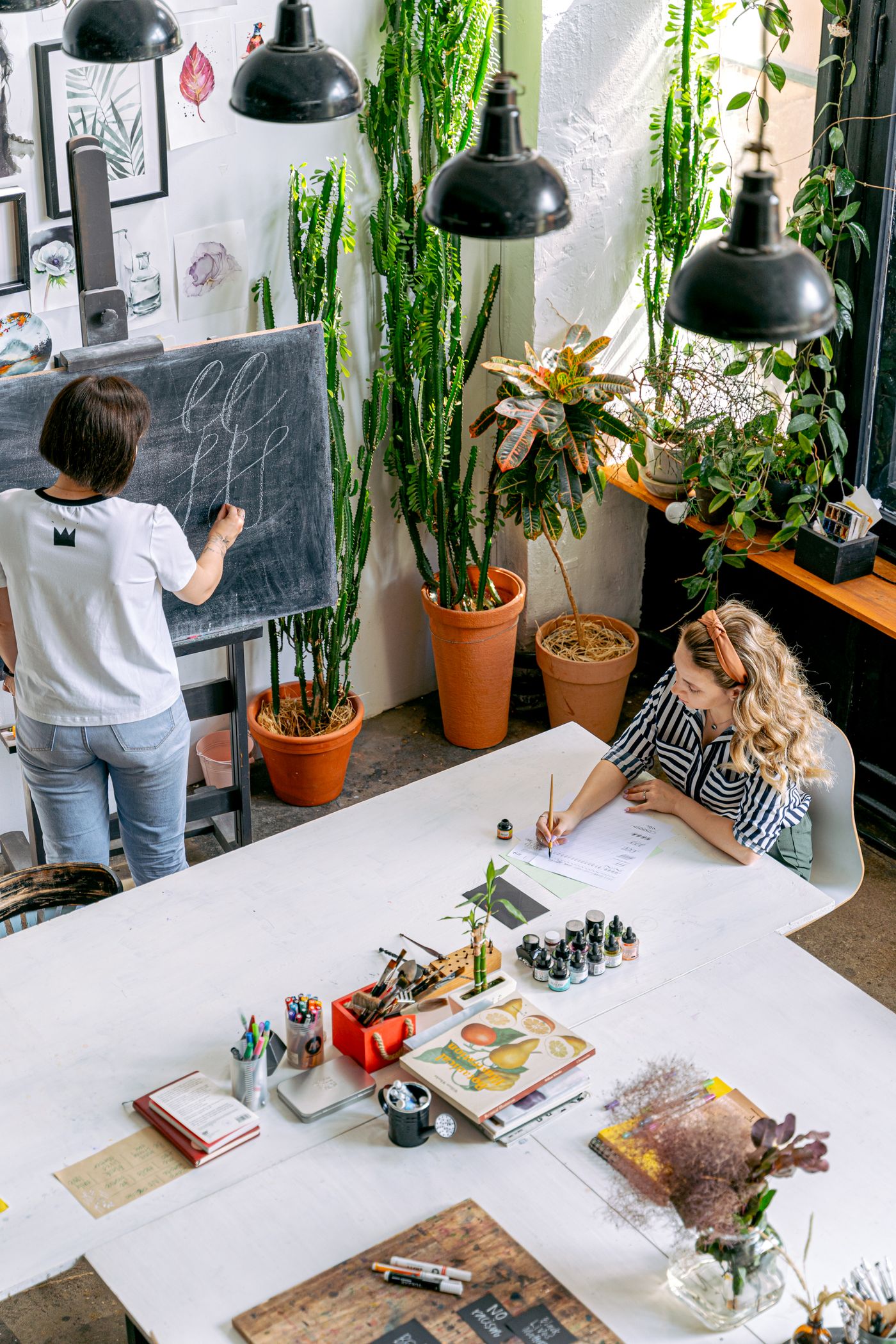 Teacher guiding a student at an art school table