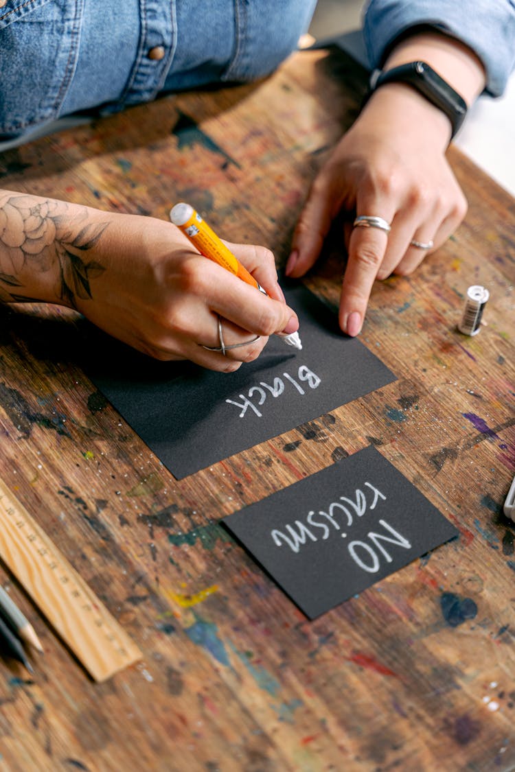 A Person Writing On Black Cards