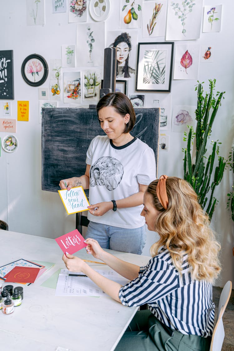 Women Holding Cards With Handwritten Lettering